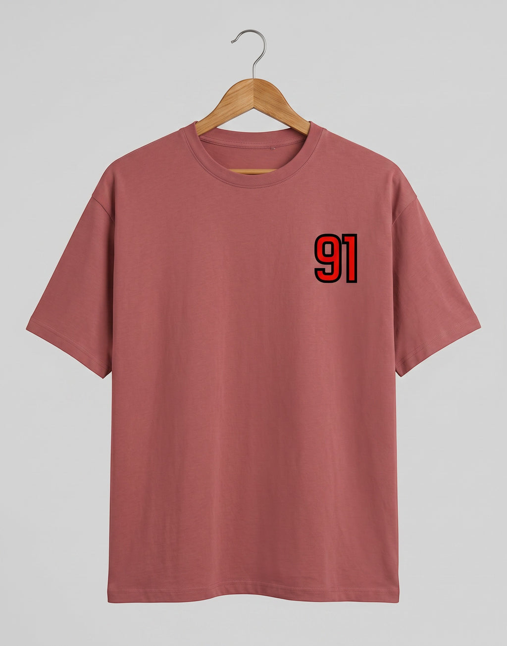 91 Varsity Left Chest graphic t-shirt on CORAL unisex classic crew soft-touch 180 GSM cotton, bold red varsity 91 left-chest pocket print signature, black outline varsity number, minimalist placement subtle distinctive, classic crew neckline timeless, unisex regular fit flattering, pre-shrunk bio-washed maintains shape