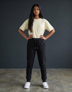 Tribe Neo 91 unisex black cotton fleece joggers with ribbed cuffs and drawstring waist worn by a model