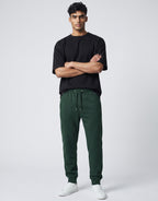 Tribe Neo 91 unisex bottle green cotton fleece joggers with drawstring waist and ribbed cuffs on a male model