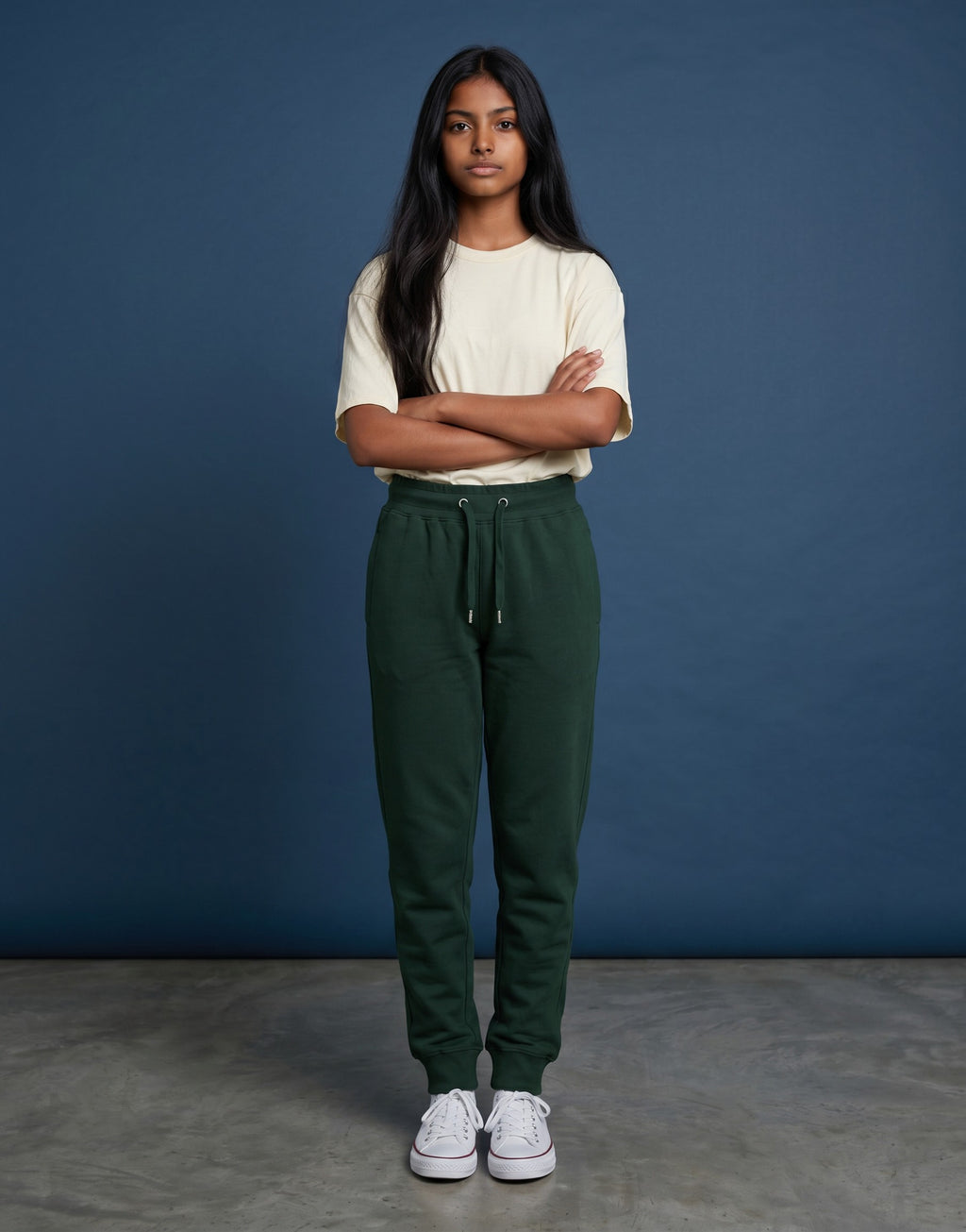 A woman wearing Tribe Neo 91 bottle green cotton fleece joggers with a ribbed waistband and tapered leg cuffs.