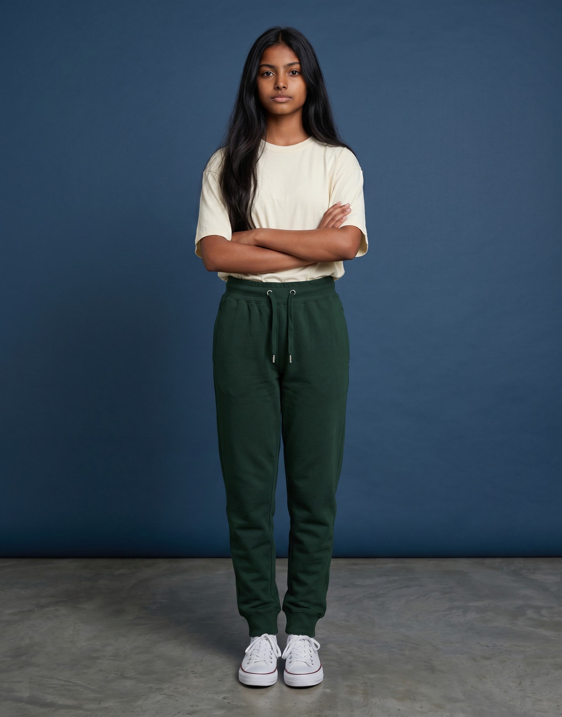 A woman wearing Tribe Neo 91 bottle green cotton fleece joggers with a ribbed waistband and tapered leg cuffs.