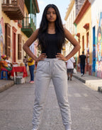 Tribe Neo 91 grey melange unisex fleece joggers with ribbed cuffs and drawstring waist worn by a woman on a street
