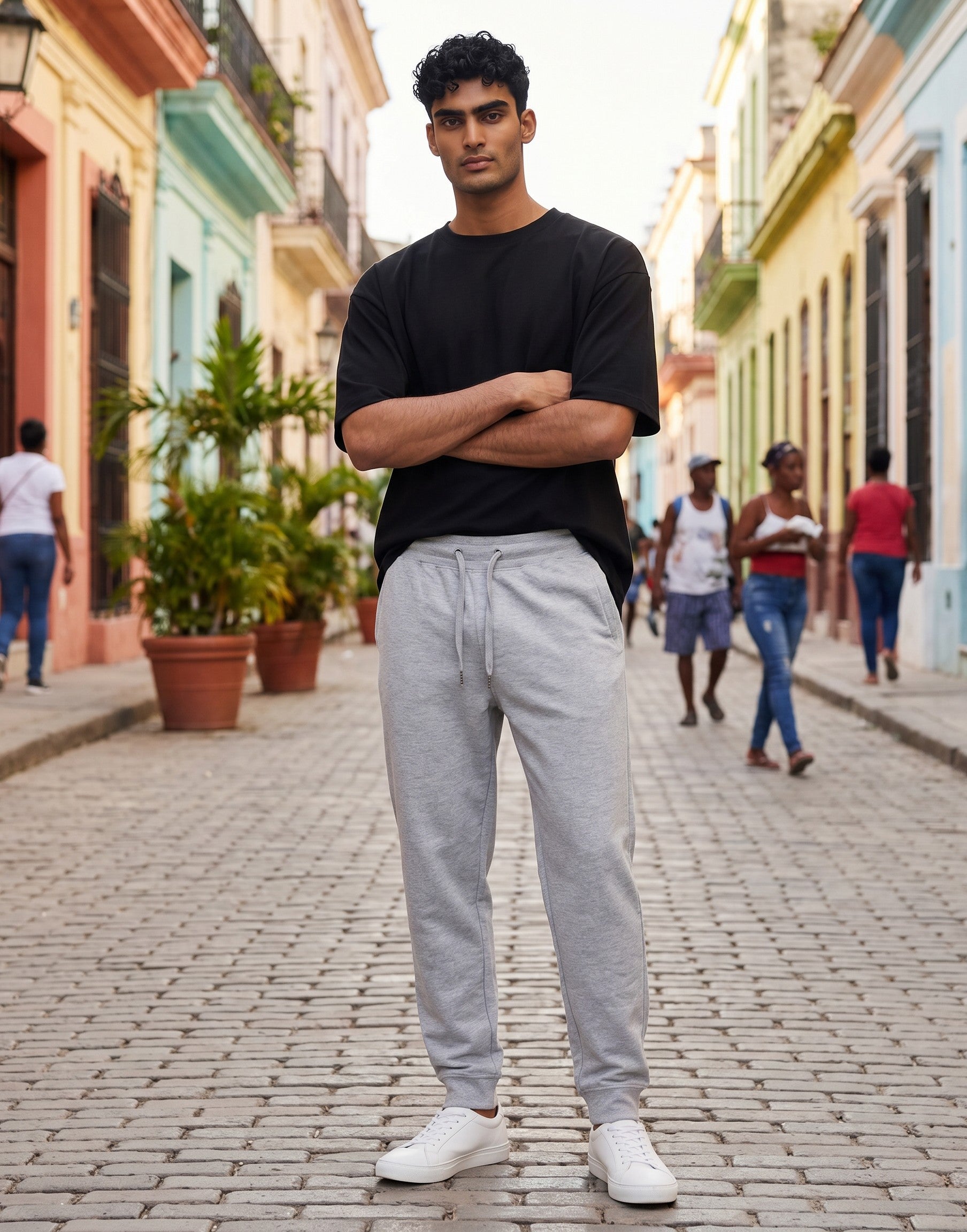 Tribe Neo 91 unisex grey cotton fleece joggers with ribbed cuffs and drawstring waist worn by a man on a city street.