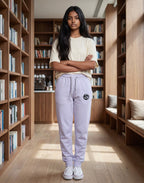Tribe Neo 91 lavender cotton fleece joggers with yin yang graphic on thigh, worn by a woman in a library setting.