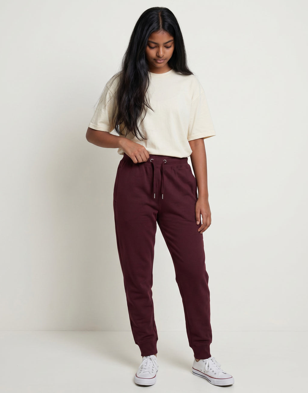 Model wearing Tribe Neo 91 maroon cotton fleece joggers with ribbed cuffs and drawstring waist in a studio setting