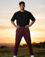 Tribe Neo 91 maroon unisex cotton fleece joggers with ribbed cuffs and drawstring waist worn by a man outdoors