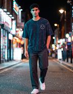 Tribe Neo 91 navy blue acid wash oversized cotton t-shirt with a small XX dead emoji graphic on a city street at night.