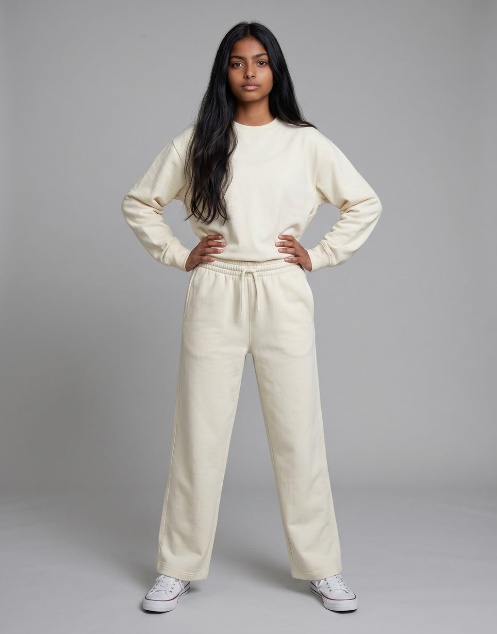 A model wearing Tribe Neo 91 off-white wide-leg cotton sweatpants and matching sweatshirt with an elastic drawstring.