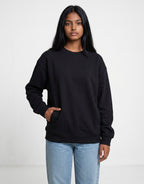 Tribe Neo 91 unisex oversized black sweatshirt with dropped shoulders and front pockets worn by a woman