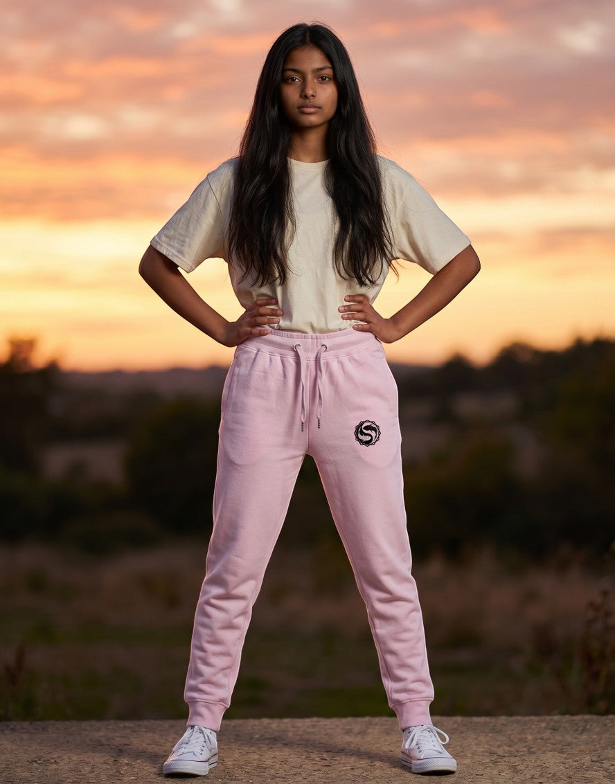 Tribe Neo 91 light baby pink unisex cotton fleece joggers with yin yang graphic, worn by a model at sunset.
