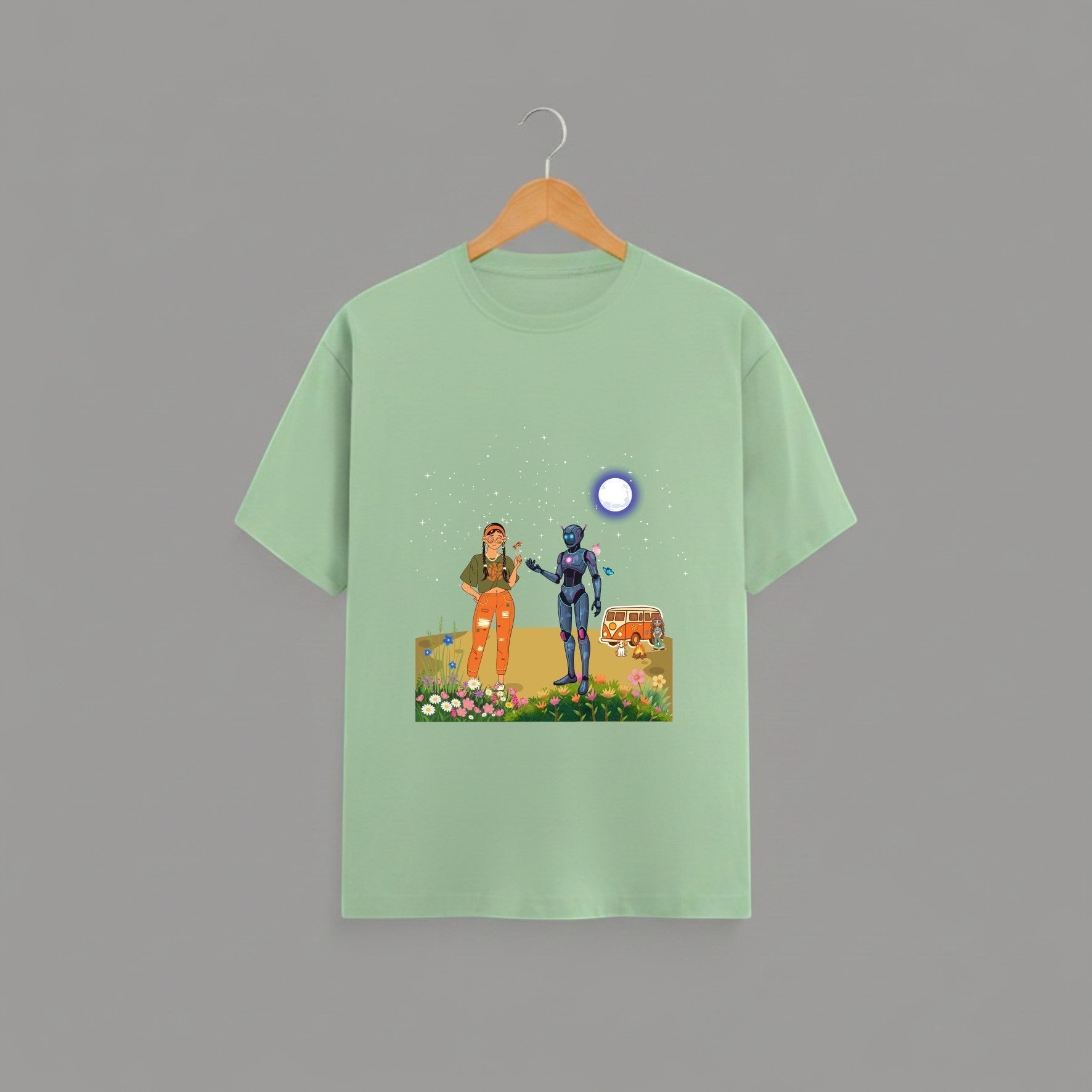 Tribe Neo 91 sage green cotton unisex t-shirt featuring a whimsical robot and human graphic print on a wooden hanger.
