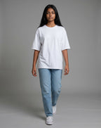 Model wearing a Tribe Neo 91 white heavyweight cotton oversized t-shirt with dropped shoulders and light blue jeans