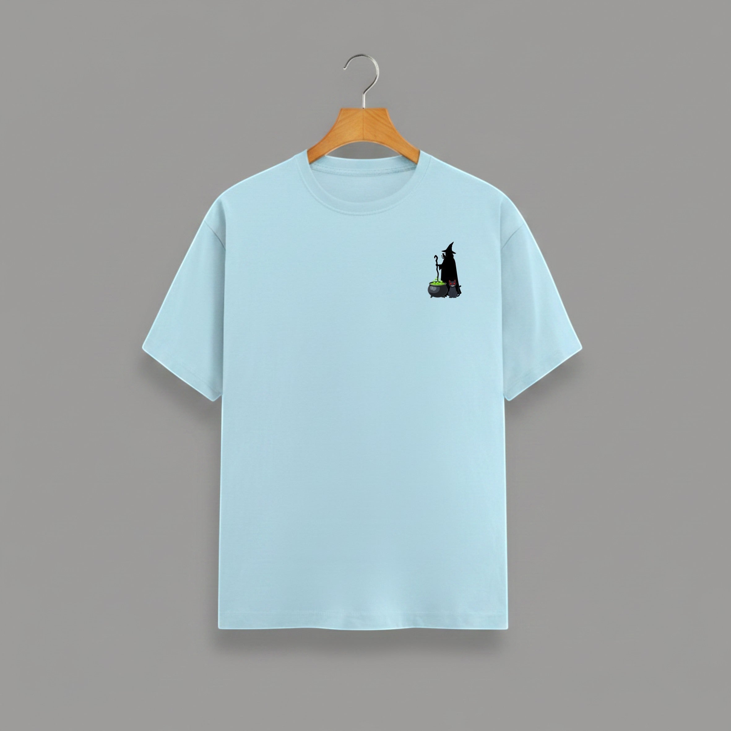 Witch Cauldron graphic t-shirt on BABY BLUE unisex 100% cotton crew neck, subtle charming witch and cauldron graphic on chest, unique eye-catching magic detail, DTG print 300 DPI, 180 GSM breathable soft fabric
