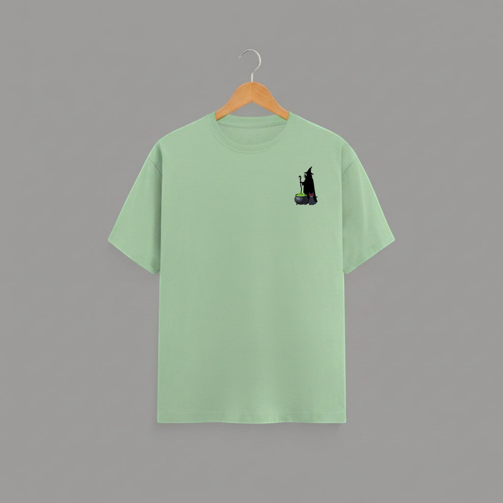 Witch Cauldron graphic t-shirt on JADE-GREEN unisex 100% cotton crew neck, subtle charming witch and cauldron graphic on chest, unique eye-catching magic detail, DTG print 300 DPI, 180 GSM breathable soft fabric