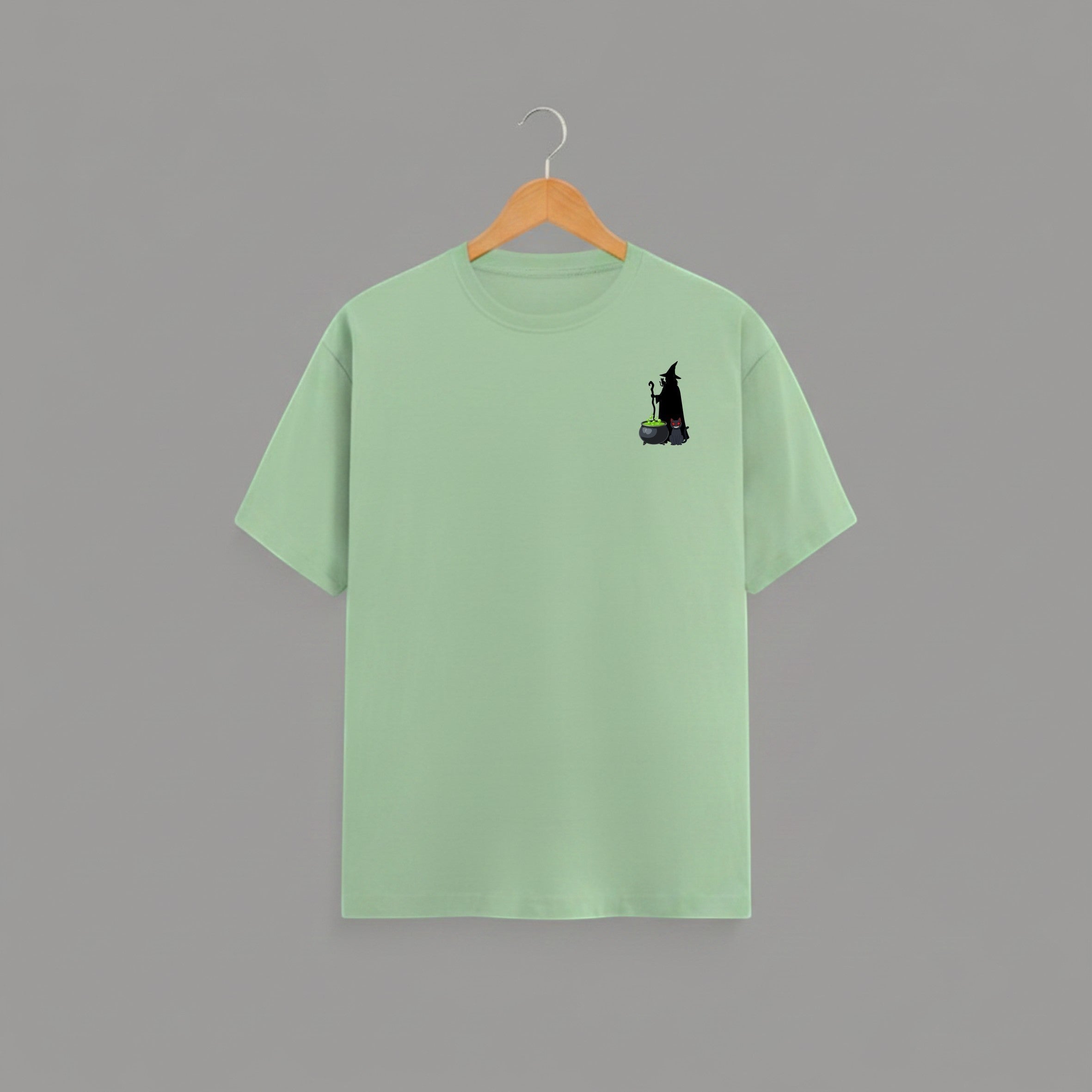 Witch Cauldron graphic t-shirt on JADE-GREEN unisex 100% cotton crew neck, subtle charming witch and cauldron graphic on chest, unique eye-catching magic detail, DTG print 300 DPI, 180 GSM breathable soft fabric